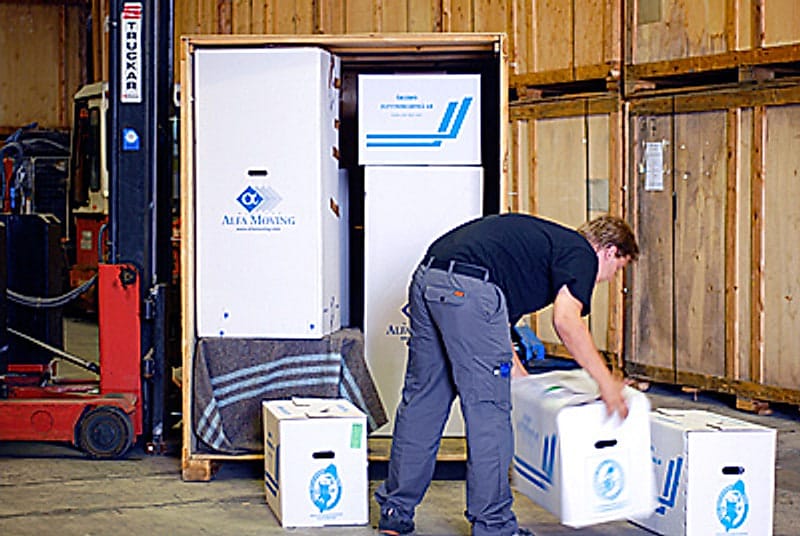 Filtemballerade möbler lastas i träcontainer